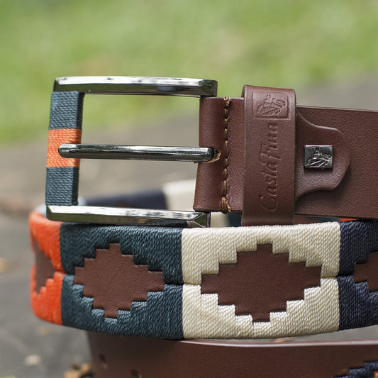 TRAVESÍA – Cada Paso es una Aventura | Cuero brandy con tejido azul cielo, naranja, verde, beige y azul oscuro – Cinturón tejido CASTAFINA clásico (Ref. TC-054)
