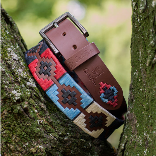 INMORTAL – Espíritu que Nunca Cede | Cuero brandy con tejido en rojo, azul cielo, beige, azul oscuro y negro – Cinturón tejido CASTAFINA PLATINO (Ref. TCP-002)