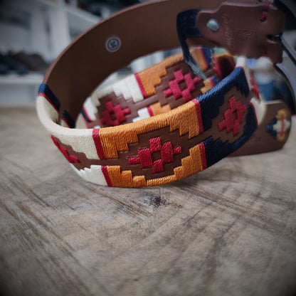 VALENTÍA – Tradición con Firmeza | Cuero caramelo con tejido en rojo, mostaza, azul oscuro y beige – Cinturón tejido CASTAFINA Platino (Ref. TC-065)
